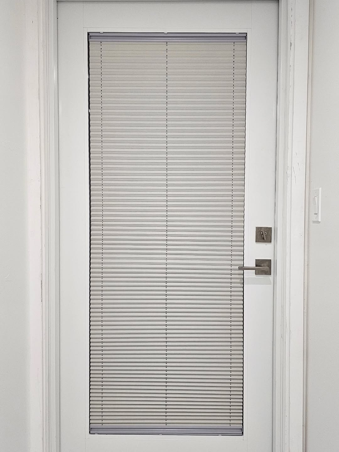 Honeycomb shade on a door-light glass panel