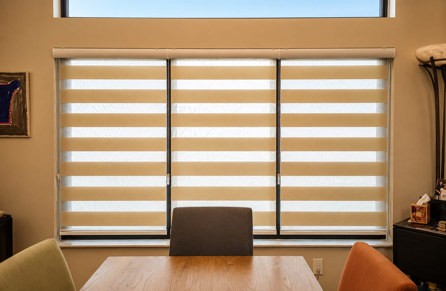 Three beige zebra blinds across an office window