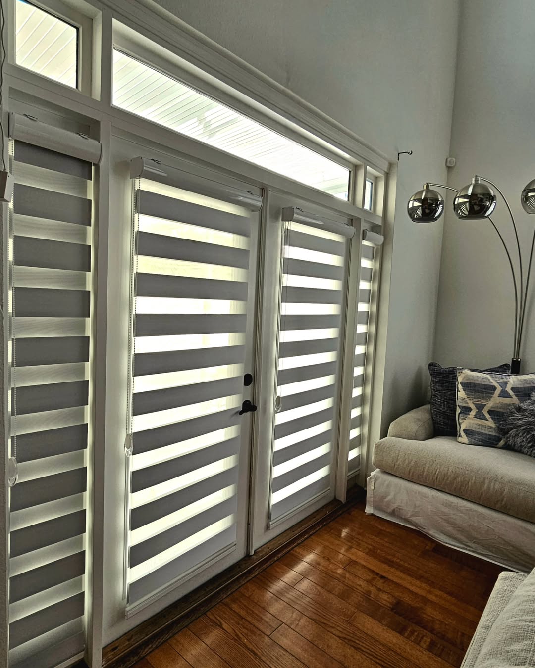 Grey zebra blinds on French doors with transom windows